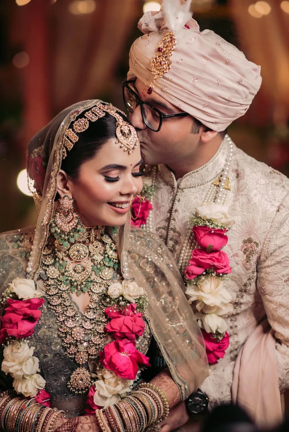 Aditi and Rohan exchanging garlands in warm light