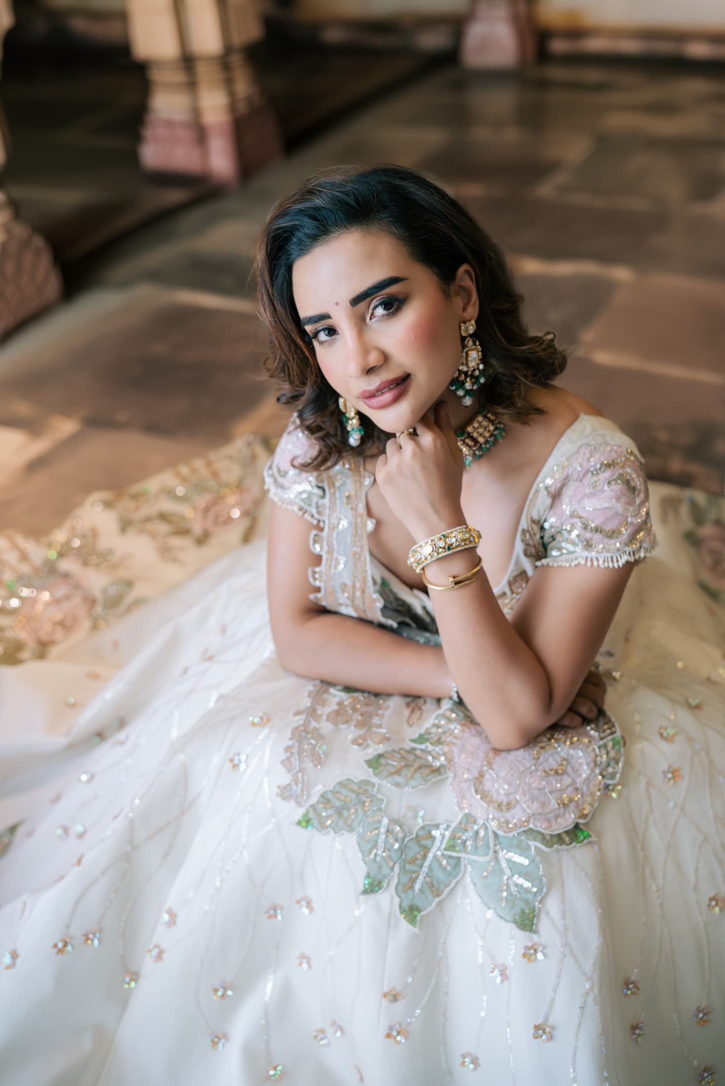 Editorial portrait in an ivory couture lehenga in a palace corridor